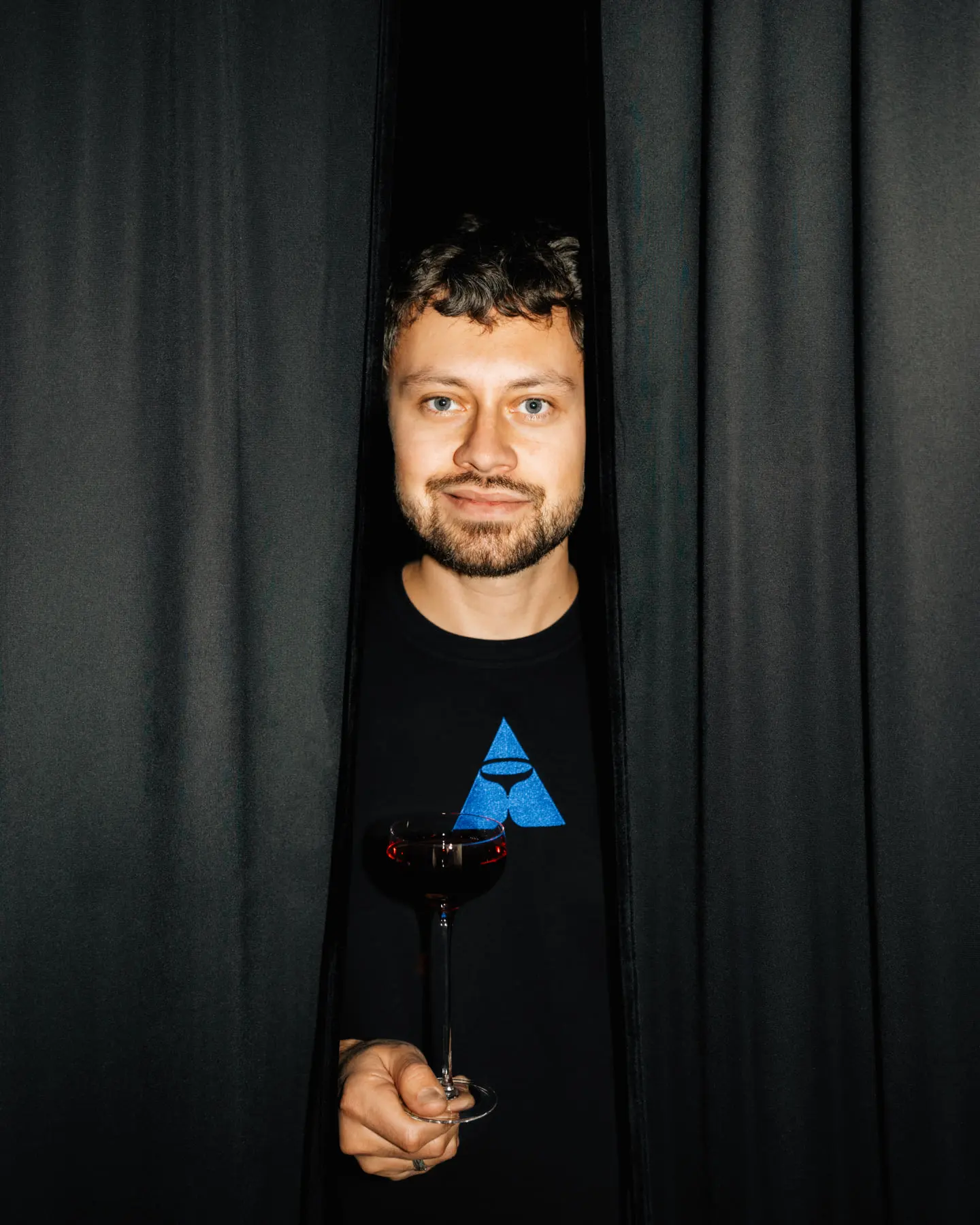 Создатель бара Сергей Щербак у входа через тёмную штору